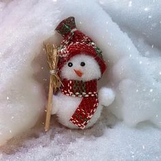 a snowman with a red hat and scarf holding a broom