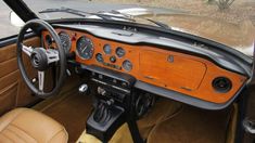 the interior of an old car with wood trim and gauges on it's dash board