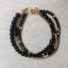 Three strands of black and gold hematite beads.  Three strands measuring 8 inches with gold lobster clasp Three Strand Bracelet, Hammered Gold, Hematite Beads, Halloween Earrings, Strand Bracelet, Stunning Earrings, Black And Gold, Blue And Silver, Lobster Clasp