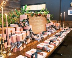 the table is set up with pink and black gift boxes