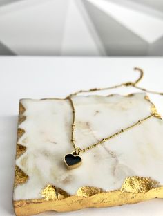 Our Double-sided Heart Necklace, made from 18k gold-plated stainless steel, is sure to make a bold and stylish statement. The timeless color combination of white and black is perfect for any occasion, whether you’re dressing up or down. Wear it with your favorite outfit and let your heart shine! 💖 Features: 18k Gold Plated High-Quality Stainless Steel Tarnish Free Stainless Steel Heart Necklace For Everyday, Black Stainless Steel Heart Pendant Necklace, Trendy Black Heart Necklace With Clavicle Chain, Gold Heart Jewelry With Black Enamel, Black Metal Jewelry With Heart Beads, Elegant Gold Stainless Steel Heart Necklace, Tarnish Resistant Stainless Steel Heart Pendant Necklace, Black Metal Heart Necklace Gift, Trendy Black Metal Heart Necklace