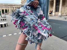 a woman's legs are covered in blue and pink pieces of fabric as she walks down the street