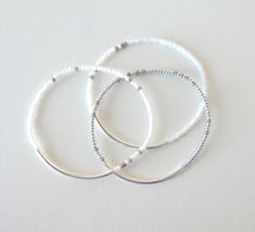 "Delicate combination of colors: the bracelets are a mix of gray white and silver beads. They are stretchy and comes in several sizes. Also choose yours at checkout. Perfect for any occasion. ❤ SIZES This item comes in several sizes. Kindly choose at checkout. The standard size for an average woman is 7\". For a child, a 6\" would be appropriate. I recommend you measure your wrist to determine the best fit. ❤ PROCESSING AND SHIPPING Most orders are made and shipped out in one business day. Pleas Delicate White Bracelets For Everyday Wear, Dainty White Stretch Bracelet For Everyday, White Dainty Stackable Stretch Bracelet, Dainty White Stackable Stretch Bracelet, Minimalist White Beaded Bracelets For Everyday, Dainty White Stretch Bracelet With Tiny Beads, Simple White Jewelry With Tiny Beads, Everyday White Jewelry With Silver Beads, Dainty White Beaded Bracelets With Silver Beads