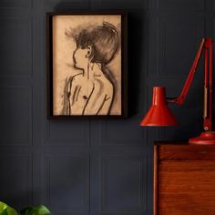 a painting hangs on the wall next to a lamp