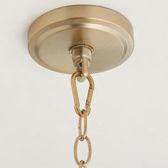 a close up of a light fixture on a white wall with a chain attached to it