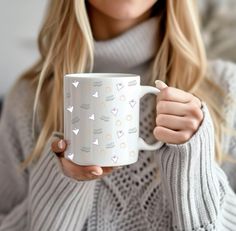 a woman is holding a coffee mug in her hands