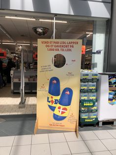 a sign in front of a store advertising flip flops on the floor for sale