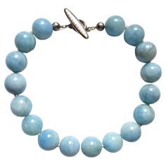 The necklace is 18.5 inches (47 cm) long. The rare size of the huge smooth round beads is 23-24 mm. The beads are a soft shade of blue sky—a very gentle, soft pastel color! These are beautiful statement beads of Blue Aquamarine! Aquamarine is a prized blue gemstone with unparalleled clarity and a soft, delicate tone that radiates life, vibrancy, and brilliance. Gemstones that are colored by nature in this way are known as allochromatic. The color is authentic and natural. No thermal or other mechanical treatments were used. This necklace alternates beads of aquamarine with 4 mm freshwater pearls. The necklace is fastened with a unique Mother of Pearl Toggle Clasp. The weight of the necklace is 323 grams. In the language of gemstones, aquamarine represents happiness, hope, and everlasting y Blue Baroque Pearl Necklace With Pearl Charm, Handmade Blue Baroque Pearl Necklace, Aquamarine Beads Necklace, Luxury Blue Polished Beads Necklace, Luxury Blue Baroque Pearl Necklace, Aquamarine Blue, Freshwater Pearl Necklaces, Blue Gemstones, Blue Crystals