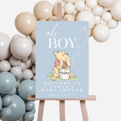 a baby shower sign with balloons in the background and an easel for it to stand on