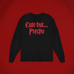 The 'Cute But Psycho' shirt is perfect for any horror fan! Whether you're looking for a gift for yourself or someone else, this t-shirt is sure to make them pull out their kitchen knife. Available in unisex sizes, this shirt is perfect for anyone who loves dark grunge fashion. Wear it while watching scary movies or while trick-or-treating. ⚰️ 100% airlume combed and ringspun cotton (fiber content may vary for different colors) ⚰️ Light fabric (4.2 oz/yd² (142 g/m ⚰️ Retail Fit ⚰️ Tear away label Halloween Horror Long Sleeve T-shirt, Horror Style Long Sleeve Tops For Streetwear, Horror Graphic Print Long Sleeve T-shirt, Long Sleeve T-shirt With Funny Text For Streetwear, Red Long Sleeve T-shirt For Halloween, Spooky Long Sleeve Shirt With Letter Print, Funny Fan Merchandise Tops With Long Sleeves, Funny Long Sleeve Tops For Fan Merchandise, Funny Long Sleeve Fan Merchandise Top