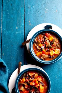 two bowls filled with soup on top of a blue table