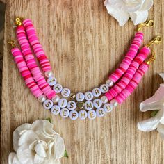 pink and white beaded necklace with flowers on wooden table next to it, which says be my bride