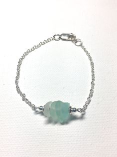 a silver bracelet with green glass beads