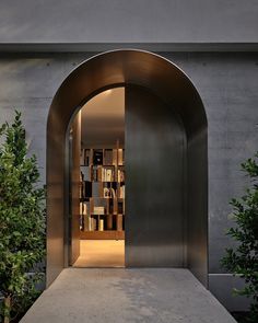 an open door leading into a room with bookshelves and trees in the background