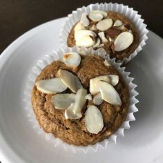 two muffins on a white plate topped with almonds