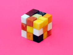 a rubik cube sitting on top of a pink surface