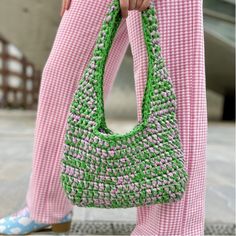 a woman carrying a green and white purse