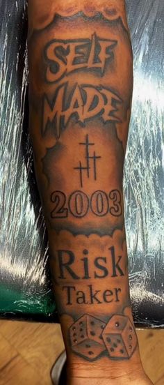 a person with a tattoo on their leg that says self made and has dices in it