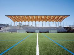 an empty soccer field with grass and blue lines on the sidelines in front of it