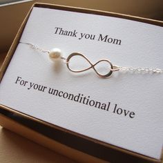 a thank you mom card with a white pearl on it and a silver chain bracelet