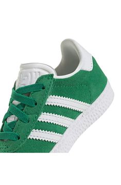 Initially designed in '91 as a training shoe for top athletes, the iconic Gazelle sneaker has been refreshed with stretchy laces for your little athlete. Pull-on style with elastic laces Leather and synthetic upper/textile lining/rubber sole Imported Green Adidas Sneakers With Laces, Green Sneakers With Laces For Jogging, Green Adidas High-top Lace-up Sneakers, Green Lace-up High-top Sneakers With Adidas Logo, White Sole Sneakers With Laces For Training, White High-top Sneakers With Elastic Laces For Jogging, Green High-top Adidas Sneakers, Green Adidas High-top Sneakers Sporty Style, Sporty Green High-top Adidas Sneakers