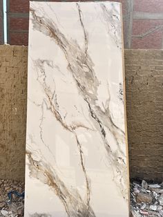 a white marble slab sitting in front of a brick wall