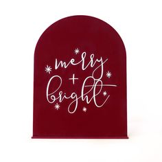 a red sign that says merry and bright with snowflakes on the top, against a white background