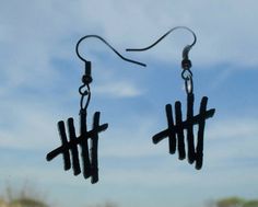 the earrings are made out of sticks and black wire with crosses hanging from each ear