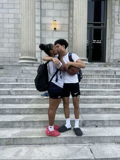 two people standing on steps kissing each other