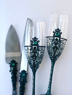 two wine glasses sitting next to each other on top of a table near a knife