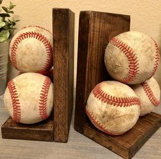 three baseballs are stacked on top of each other in a wooden stand next to a potted plant