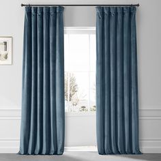 a blue curtain hanging on the side of a window in front of a white wall