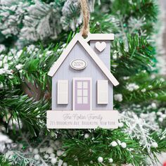 a house ornament hanging from a christmas tree