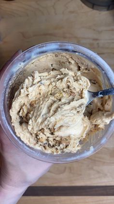 a hand holding a bowl filled with ice cream