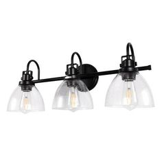 three light bathroom fixture with clear glass shades and black metal finish on an isolated wall