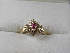 Ruby and Diamond Ring set with a natural marquise ruby that measures 5X2.5mm and is .20Carats. The baguette and round diamonds surrounding the ruby measure approximately .50 Carats. This is a dainty ring and very pretty on the hand. It is solid 10K yellow gold and weight 3.2 grams. Currently a size 6.75 (6 3/4) The ring can be sized up or down as needed. Ruby is July Birthstone. Great engagement ring also. Actual item is pictured but greatly enlarged for detail. All measurements are taken in mou Ruby And Emerald Ring, Ornate Gold Ring With Ruby, Victorian Gold Ring With Ruby, Ornate Gold Ruby Ring, Victorian 14k Gold Ruby Ring Gift, Victorian Ruby Rings In Yellow Gold, Ruby Wedding Ring, Filigree Diamond Ring, Cats Eye Ring