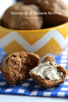 two muffins on a blue and white napkin next to a yellow bowl