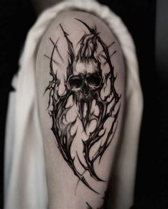 a black and white photo of a skull with flames on it's head tattoo