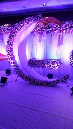 the stage is set up for an event with purple lighting and white drapes on it