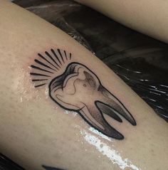 a tattoo on the leg of a woman with an animal's head and sunburst