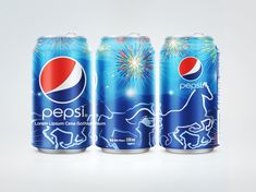 three cans of pepsi are shown with fireworks in the sky and horses on the side