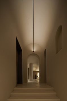 an empty hallway with white steps leading up to the door