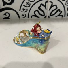 the little mermaid figurine is on display