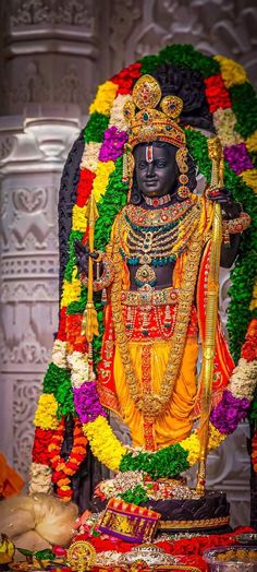 an idol is displayed in front of flowers