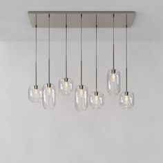 a bunch of lights that are hanging from a ceiling fixture in a room with white walls