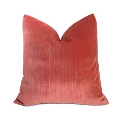 an orange velvet pillow on a white background