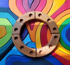 a circular wooden object mounted to the side of a colorful wall