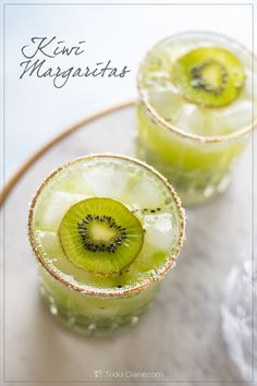 two glasses filled with kiwi margaritas on top of a table