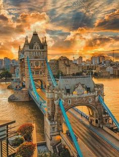 an aerial view of the tower bridge in london, england at sunset with clouds overhead