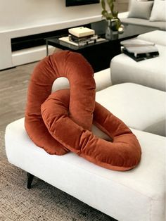 an orange pillow sitting on top of a white couch